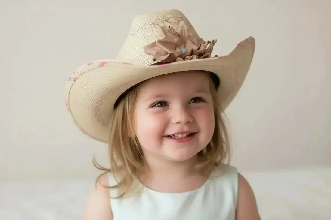 Little girl wearing a cowgirl hat with a leather flower + Kingman Turquoise hat band.
