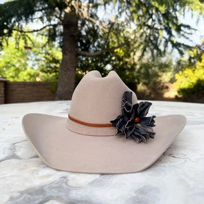 Cowgirl Hat w/ Black Leather Flower Red Jasper Stone Hat Band on a stone table with nature in the background.