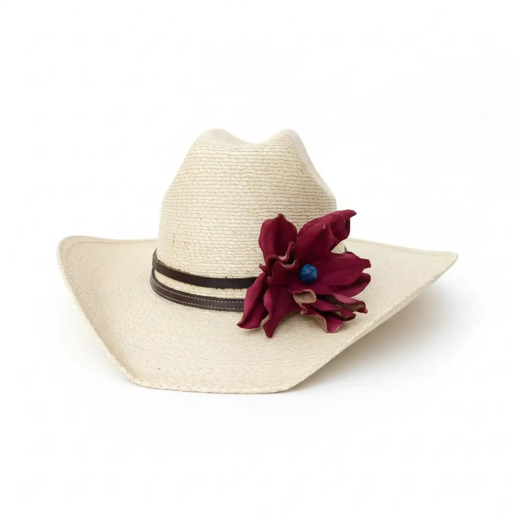 Beige straw cowgirl hat with a red flower and black band on a white background