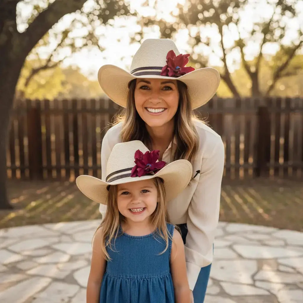 Mom and daughter wearing Mommy and Me matching cowgirl hats w/ a red leather flower and blue lapis stone hat band