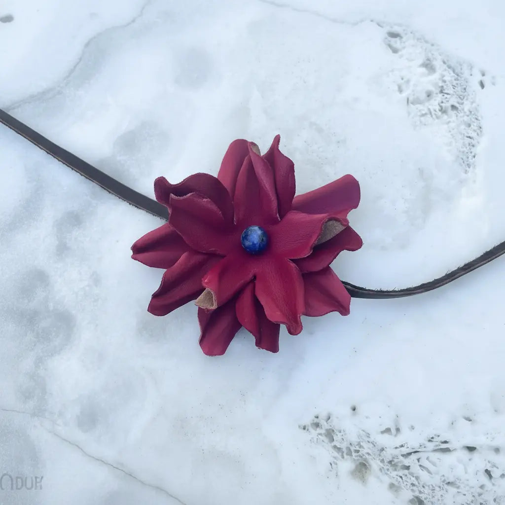 Red leather flower hair bow and headband with blue lapis stone. Also, a cowgirl hat band on a pretty white stone background.