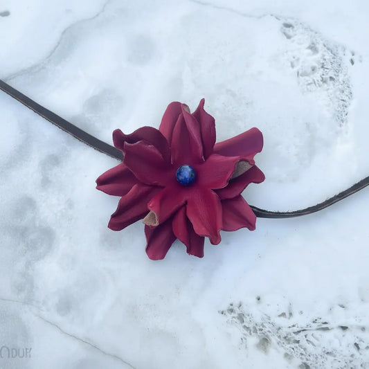 Red leather flower hair bow and headband with blue lapis stone. Also, a cowgirl hat band on a pretty white stone background.